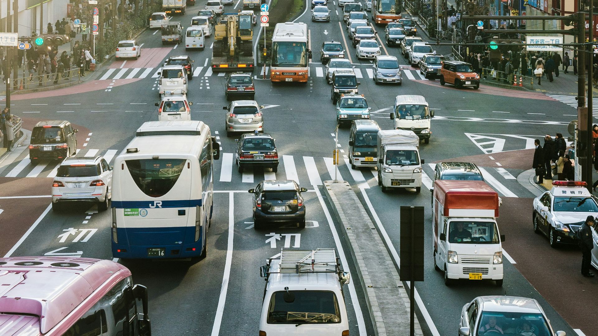 highway road filled with cars surrounded by high rise buildings