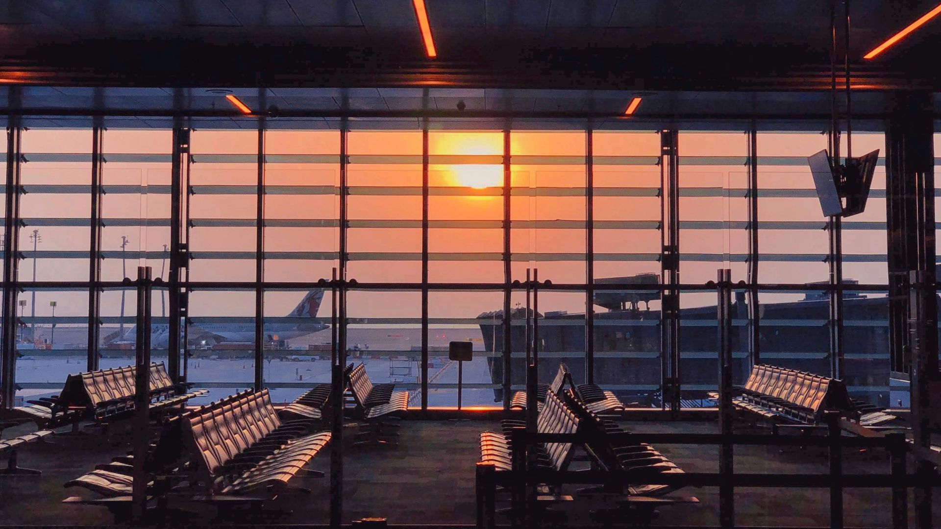 the sun is setting through the window of an airport