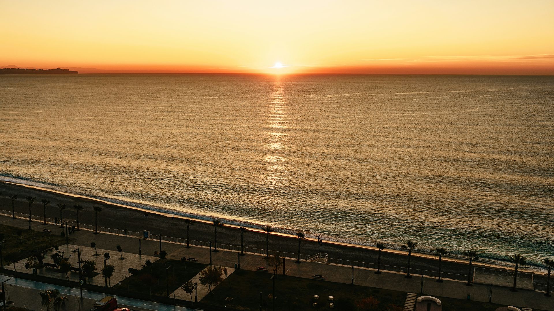 the sun is setting over the ocean on the beach