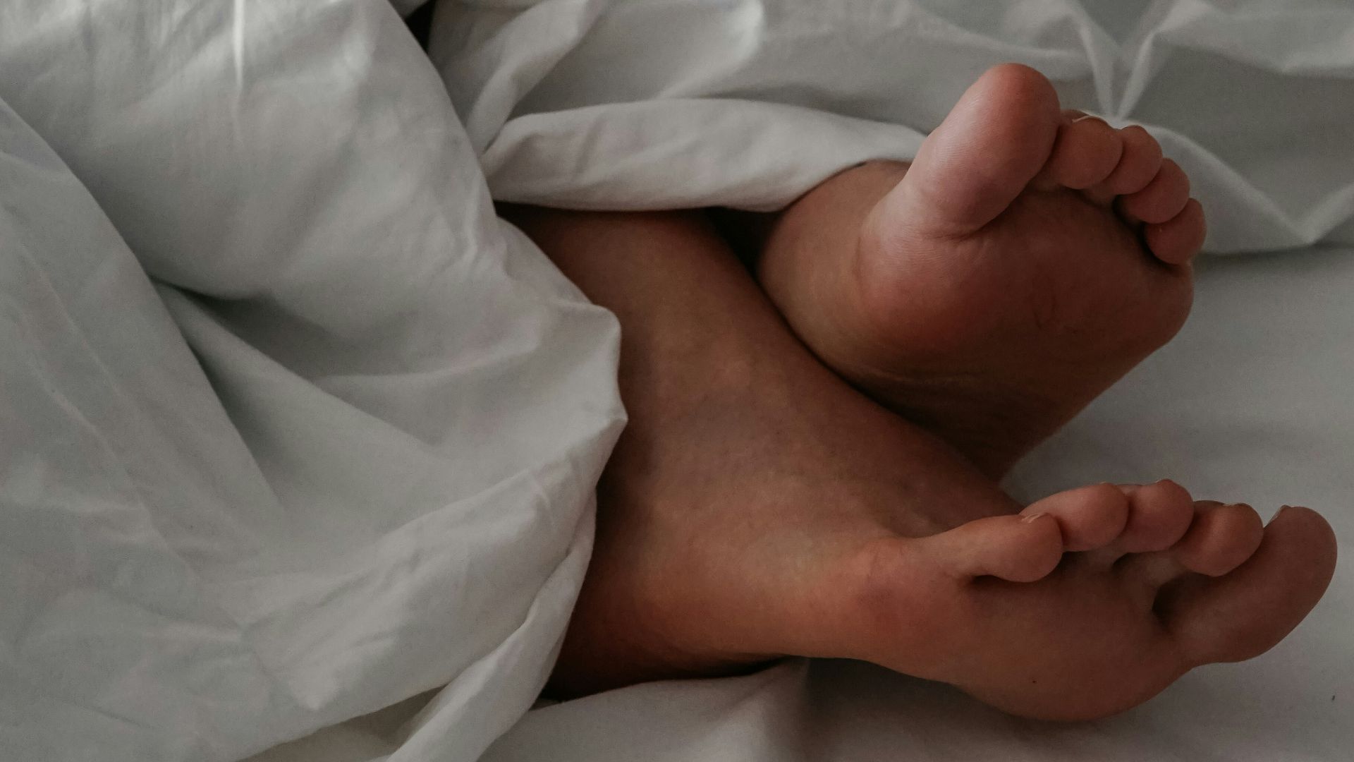 baby lying on white bed
