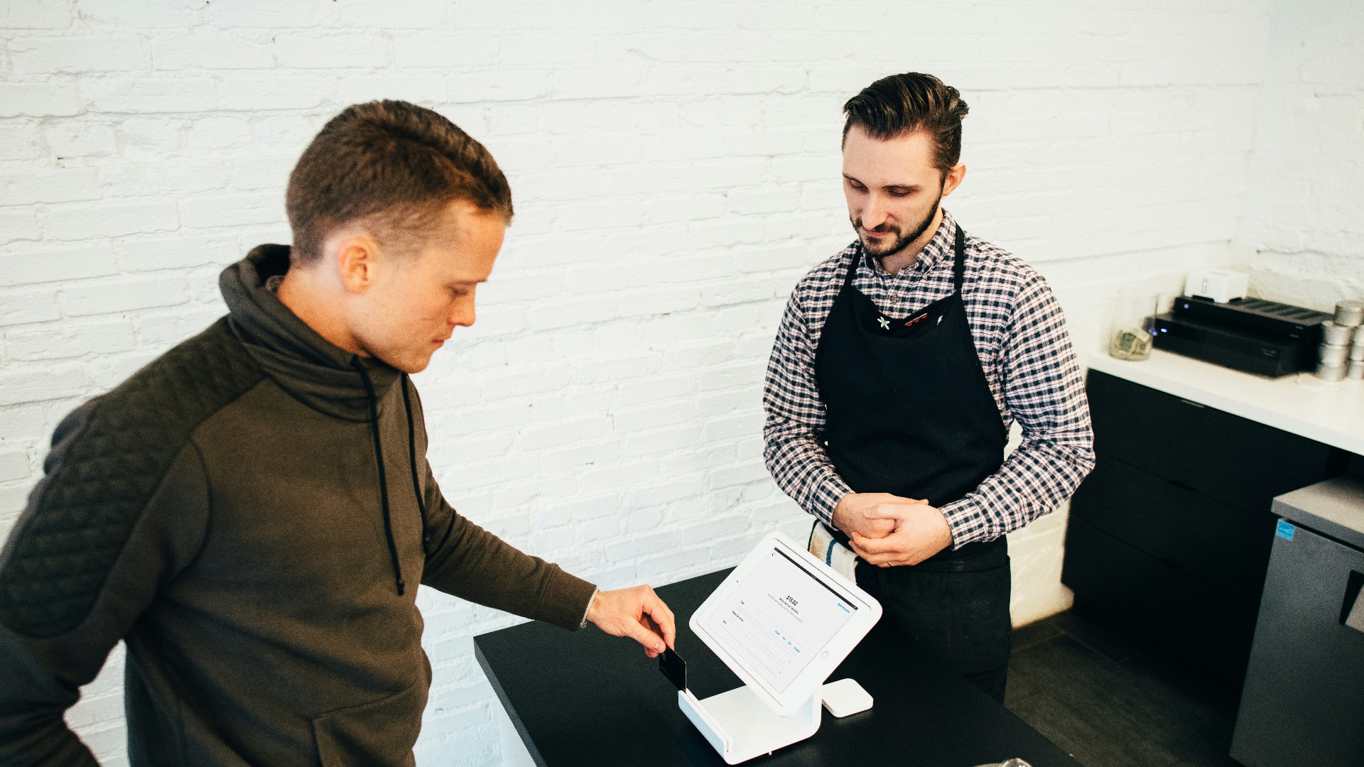 man looking at white digital device
