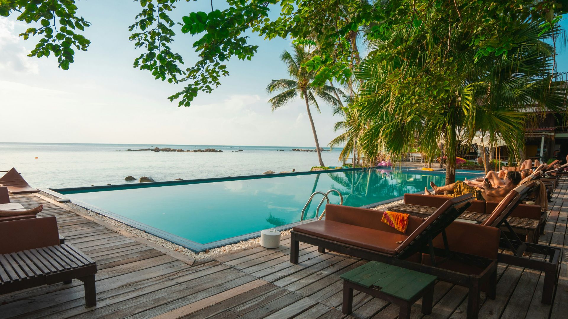 brown wooden table and chairs on brown wooden deck near body of water during daytime