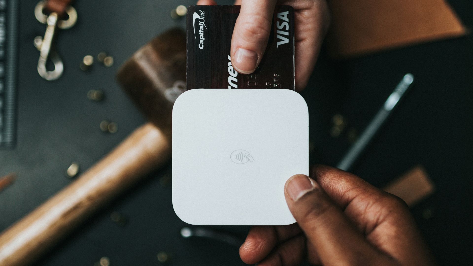 person holding Visa card and white device