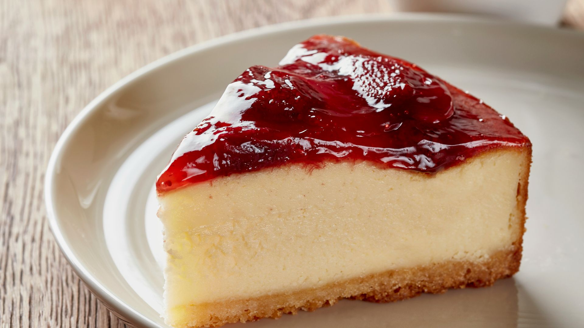 a piece of cheesecake on a plate next to a cup of coffee
