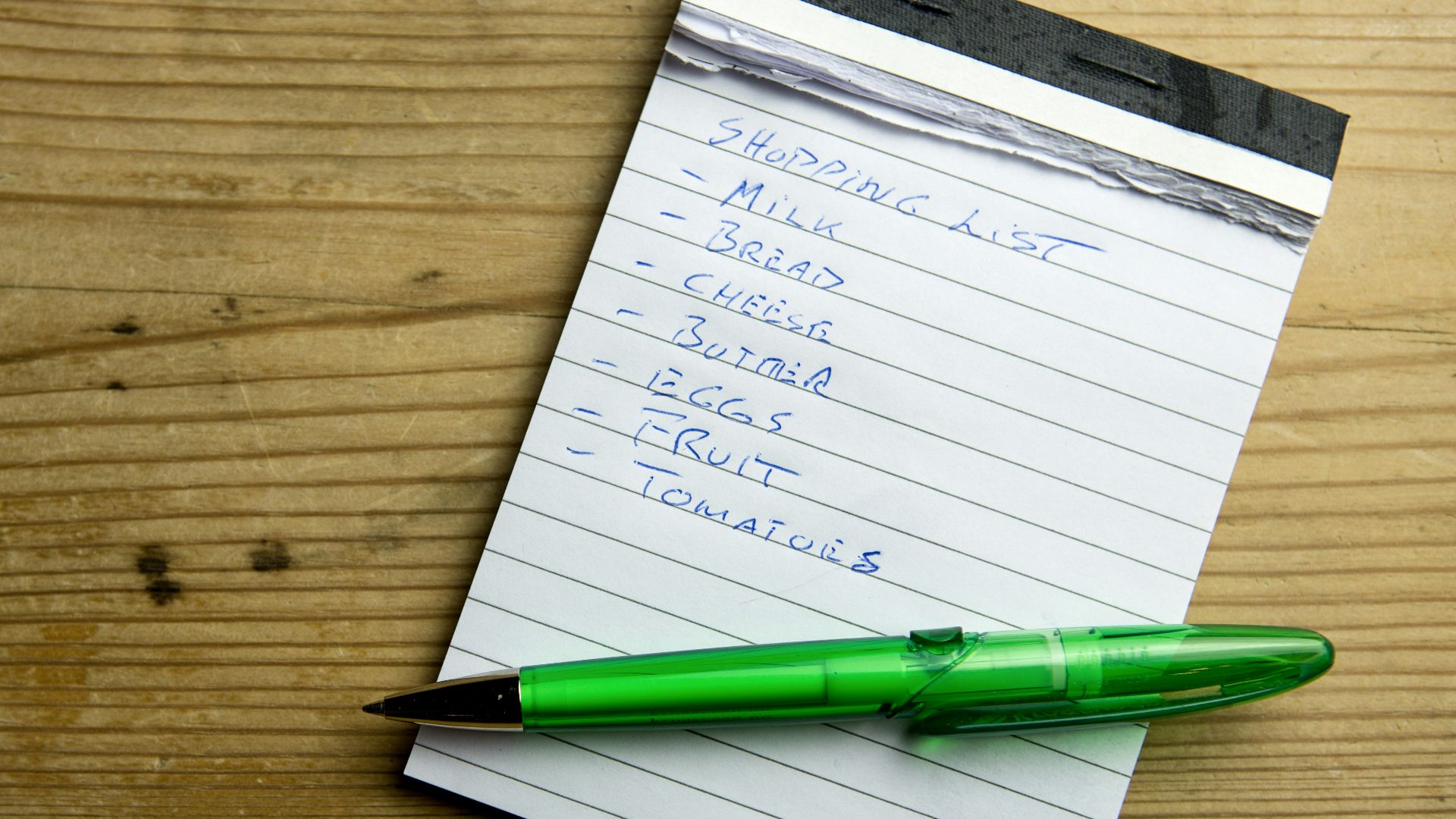 a notepad with a green pen on top of it