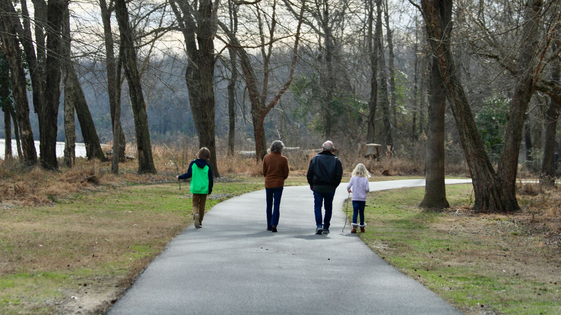a group of people walking down a path in a park