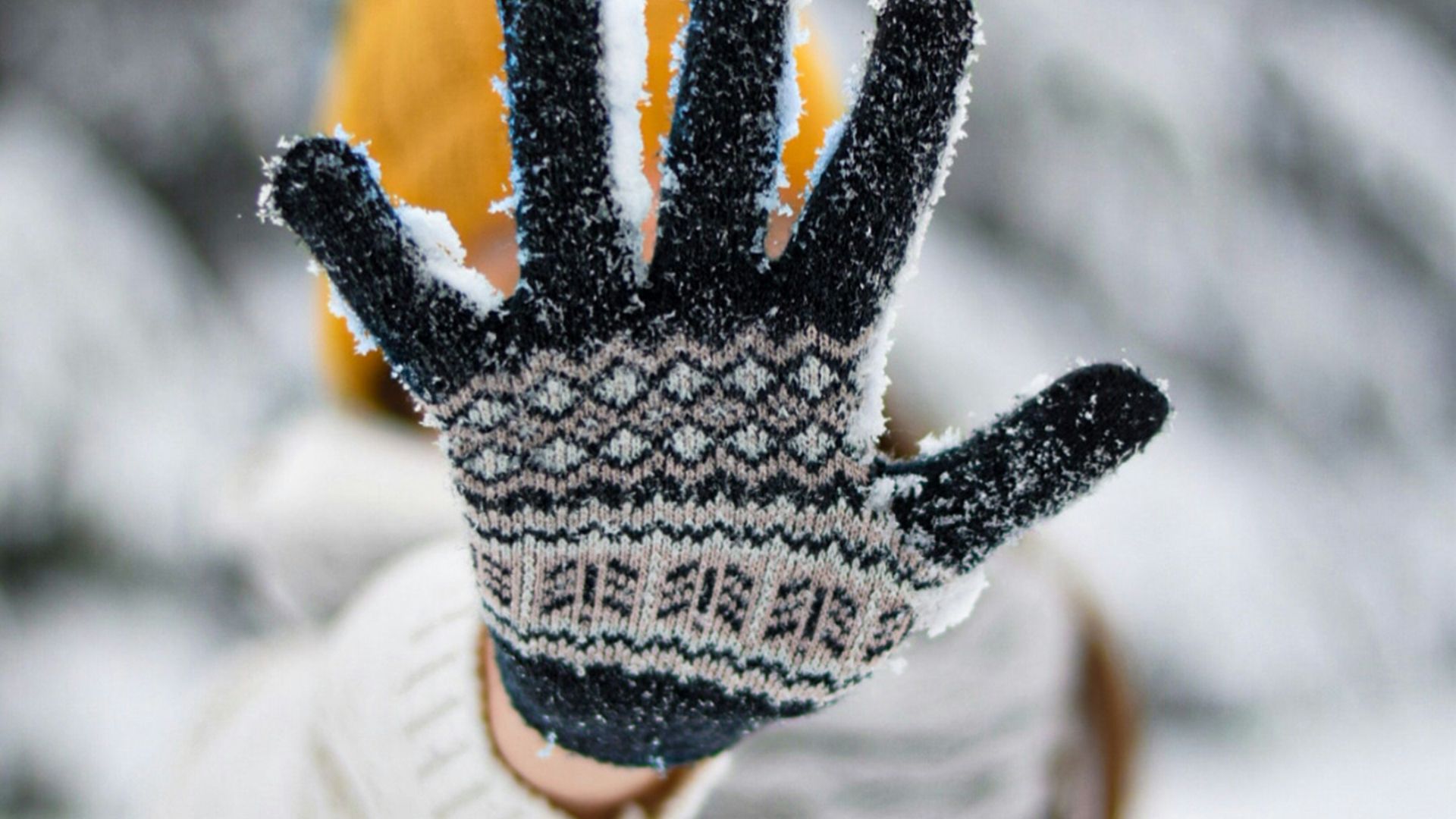 person in white and black knit gloves