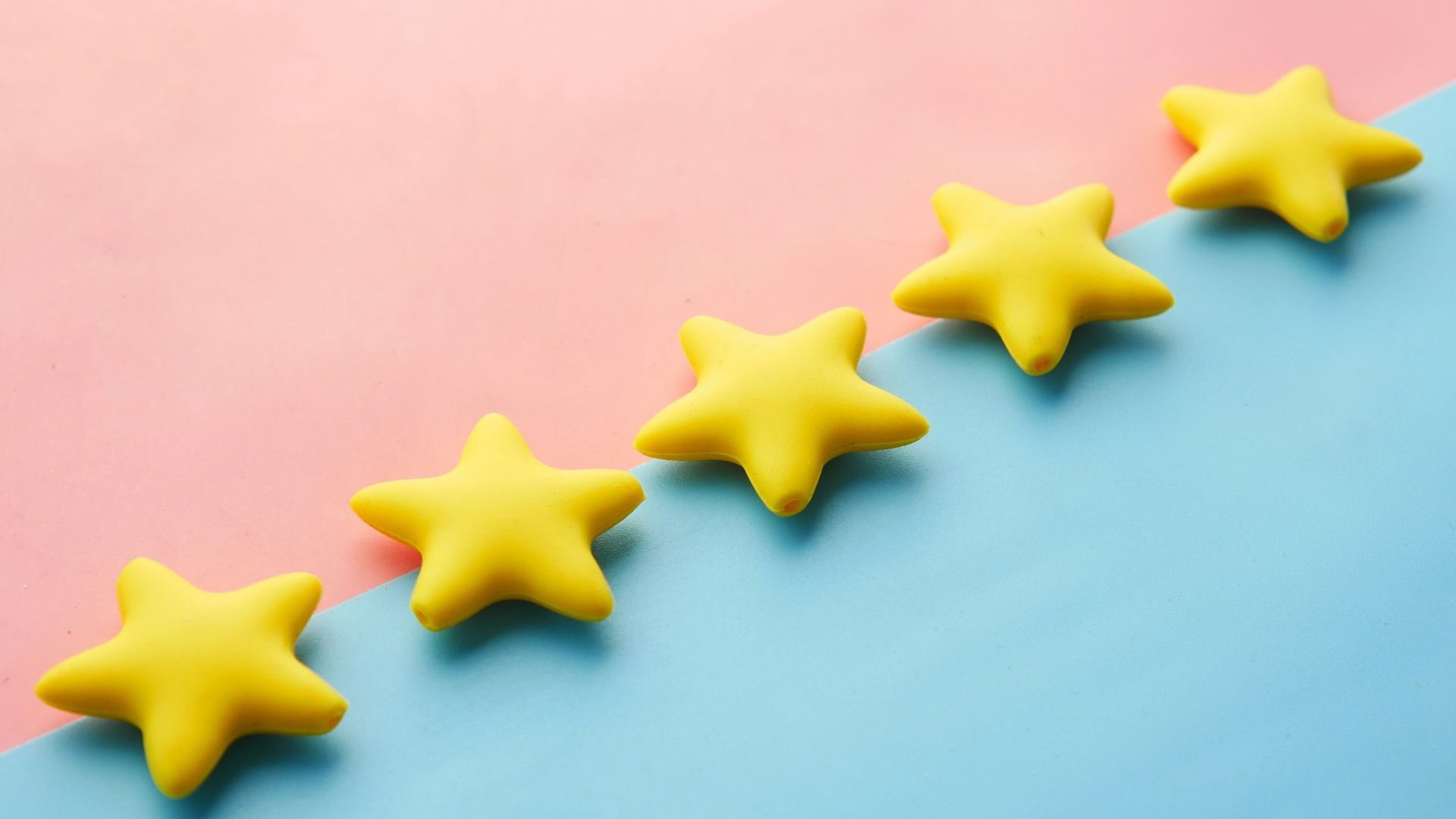 a row of yellow stars sitting on top of a blue and pink surface
