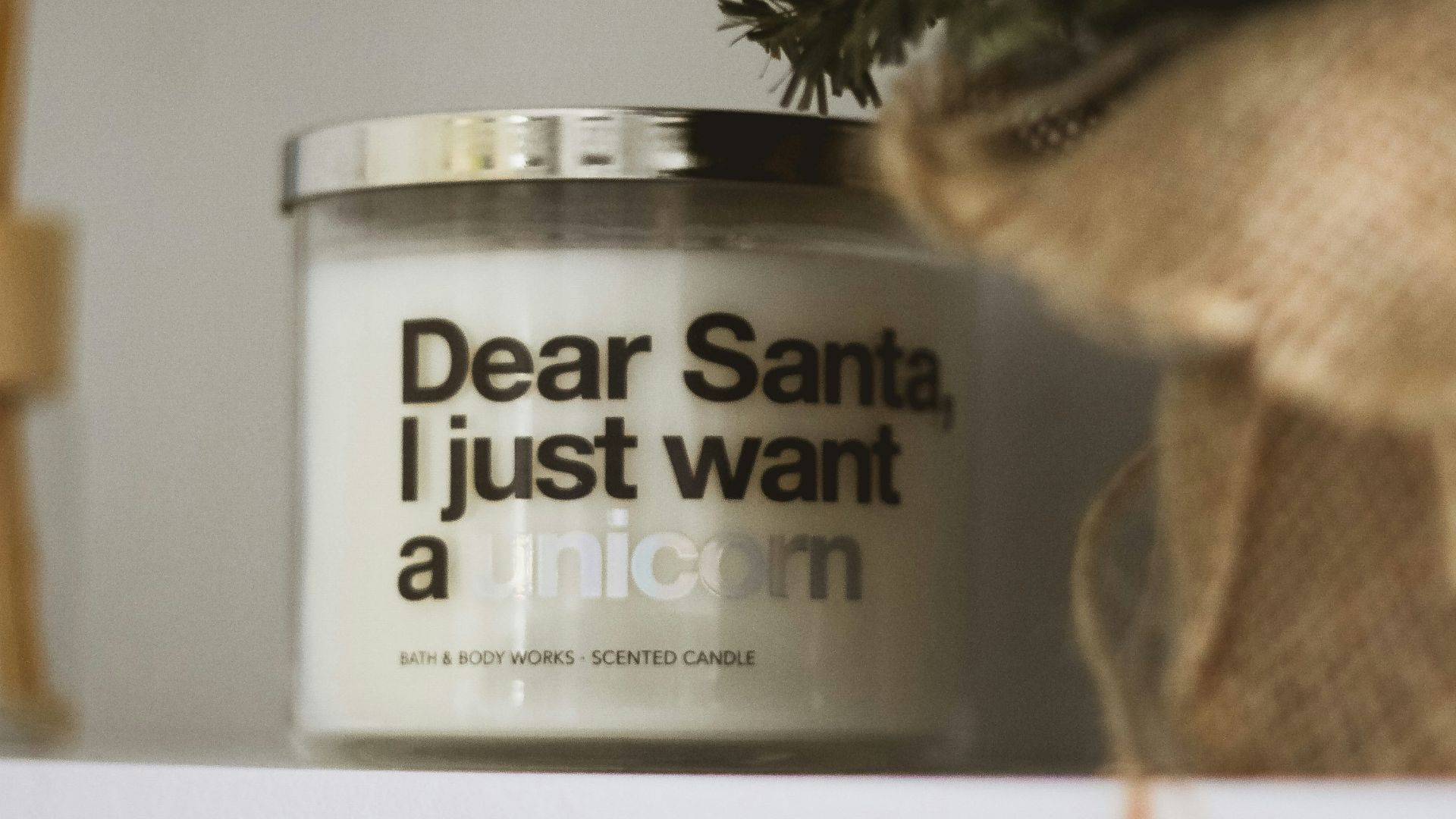 a white candle sitting on top of a shelf