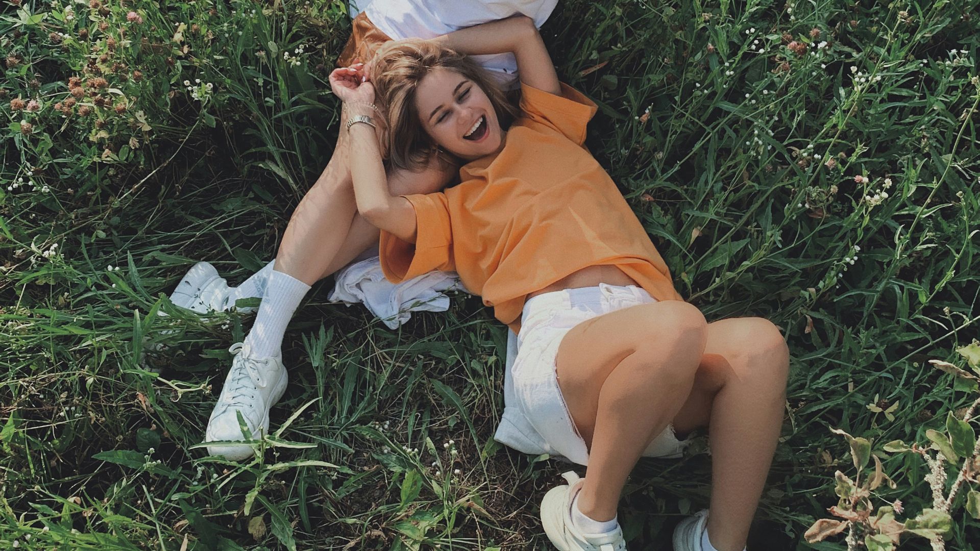 woman in white shirt sitting on green grass