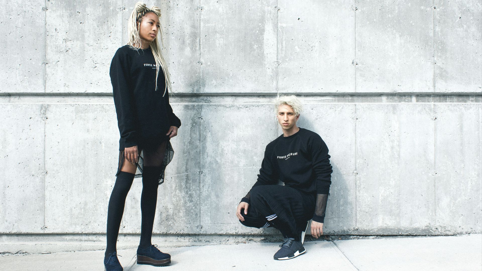 man kneeling and woman standing near wall