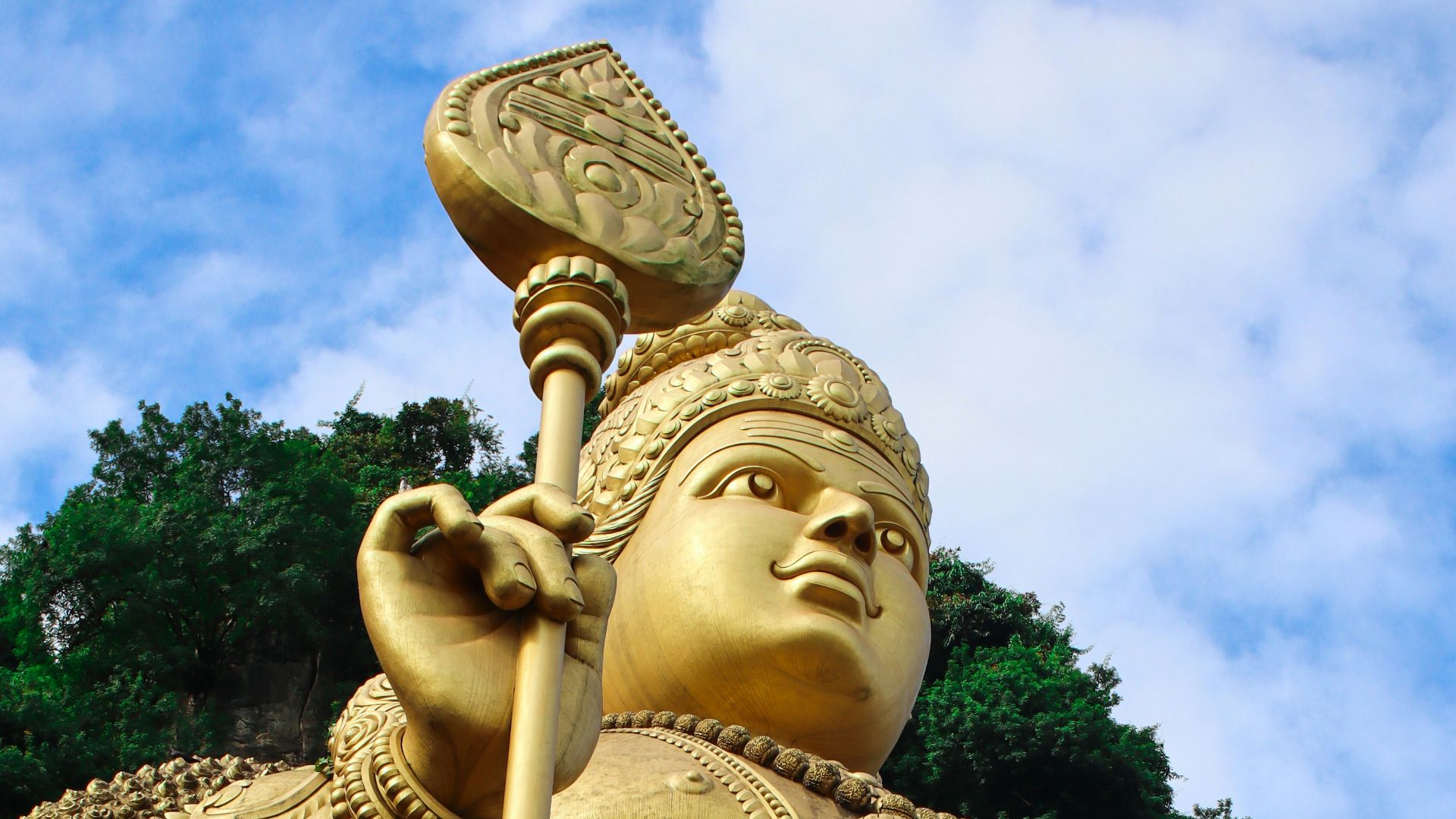 A large golden statue of a man holding a spear