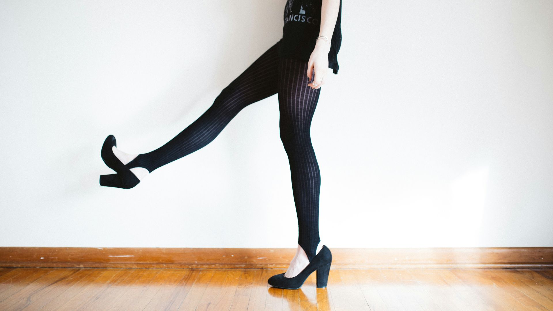 woman raising her right leg near wall
