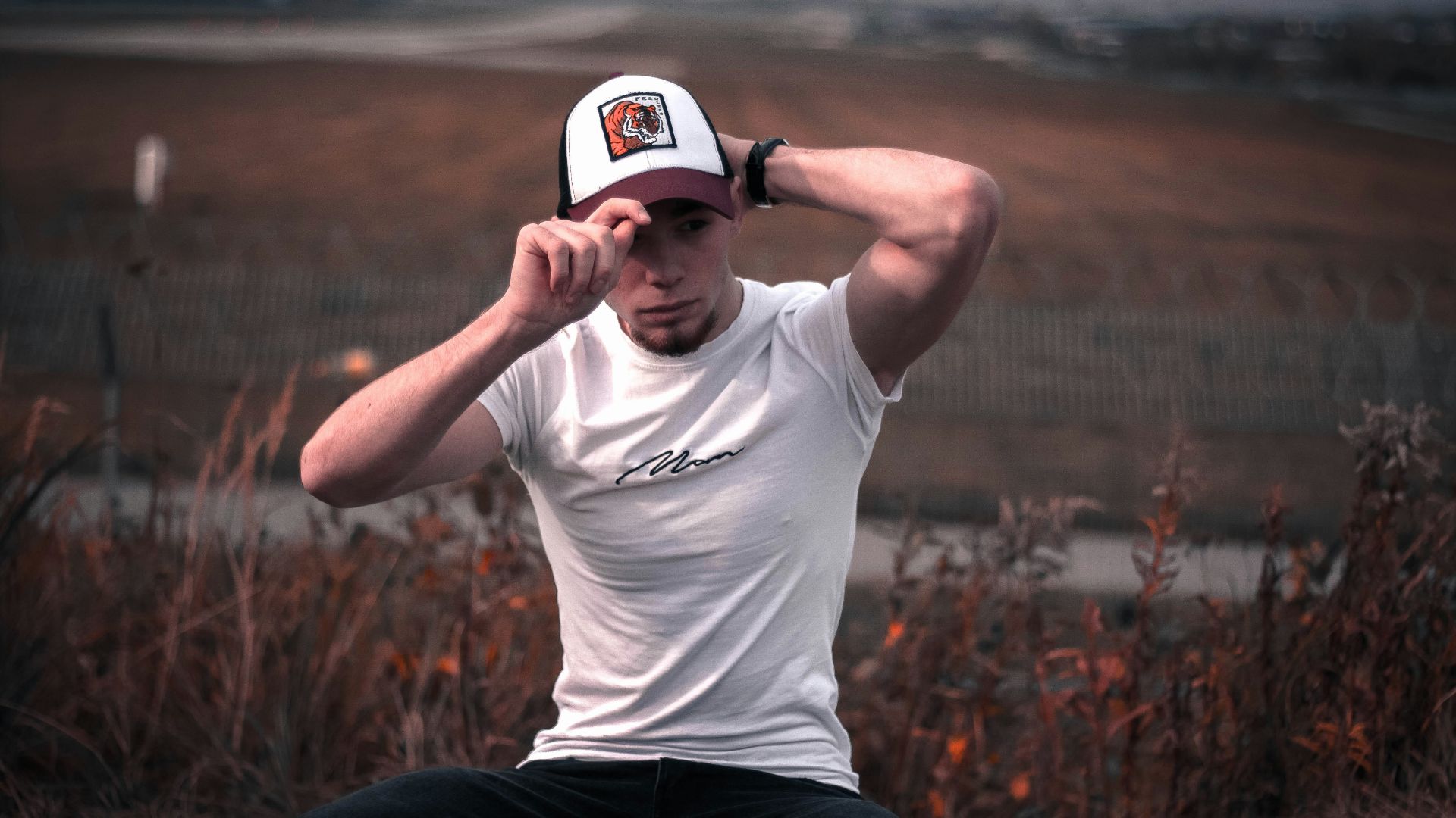 man in white crew neck t-shirt and black pants wearing white cap