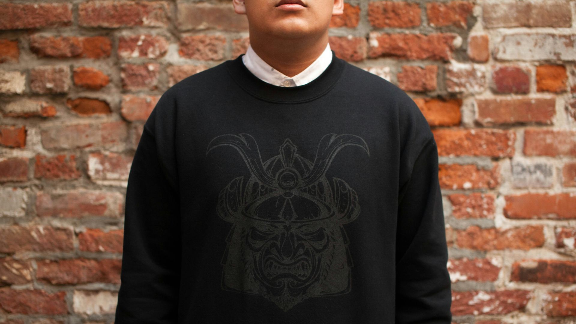 man standing near brown bricked wall