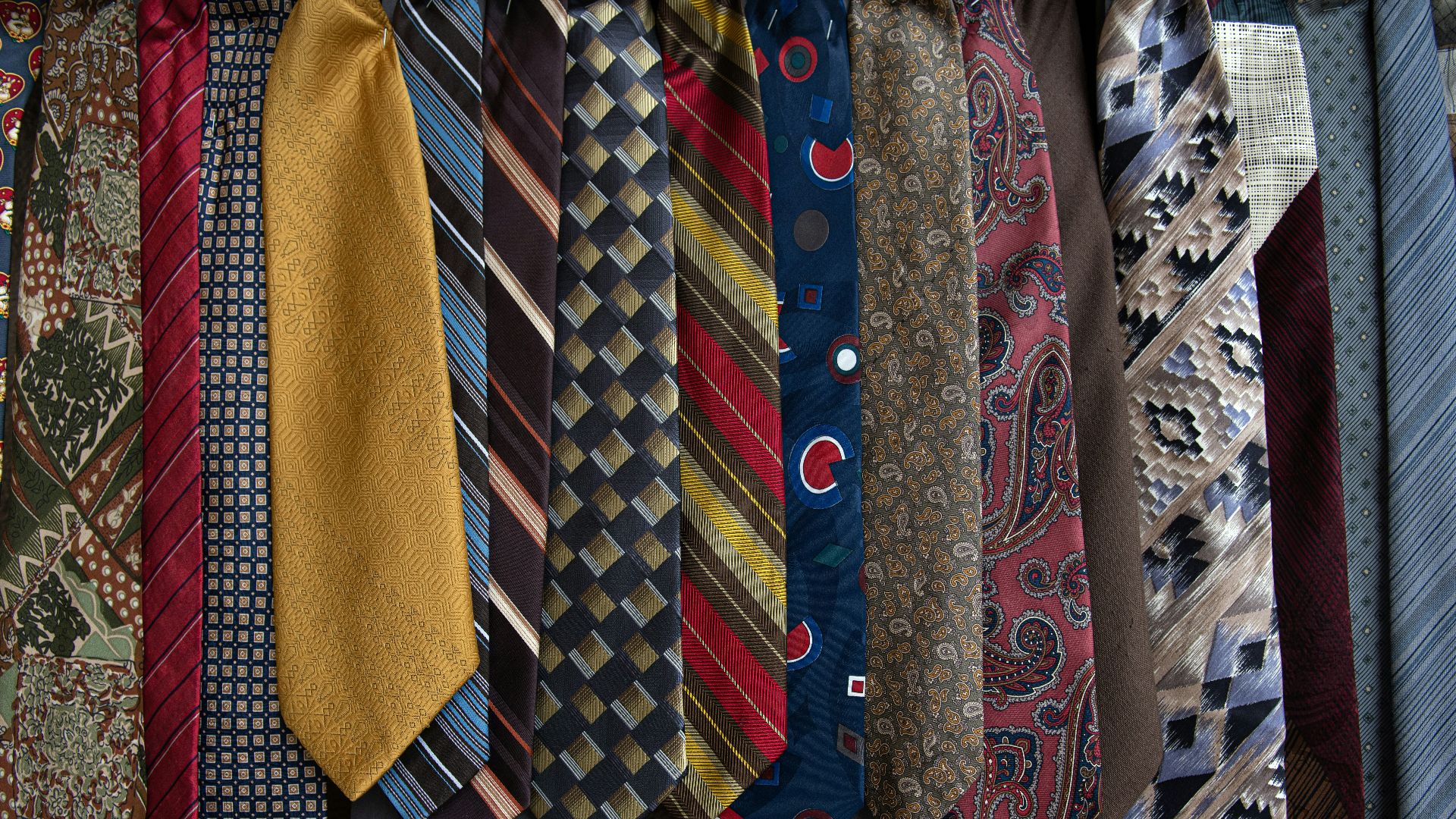 brown and white necktie on blue and white floral textile