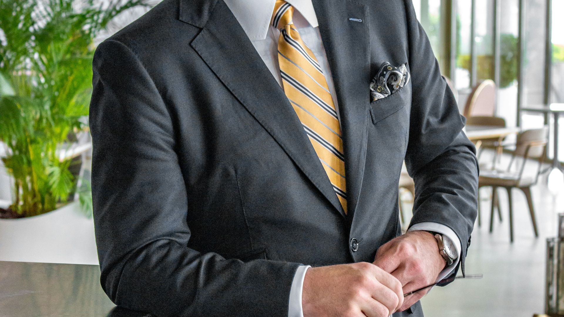 a man in a suit is holding a tie