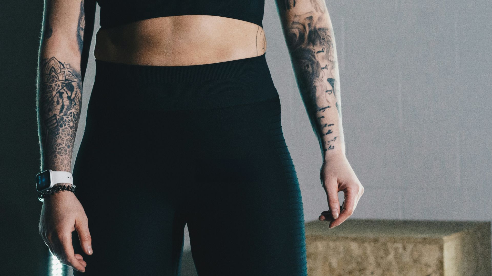 a woman in a black sports bra top and leggings