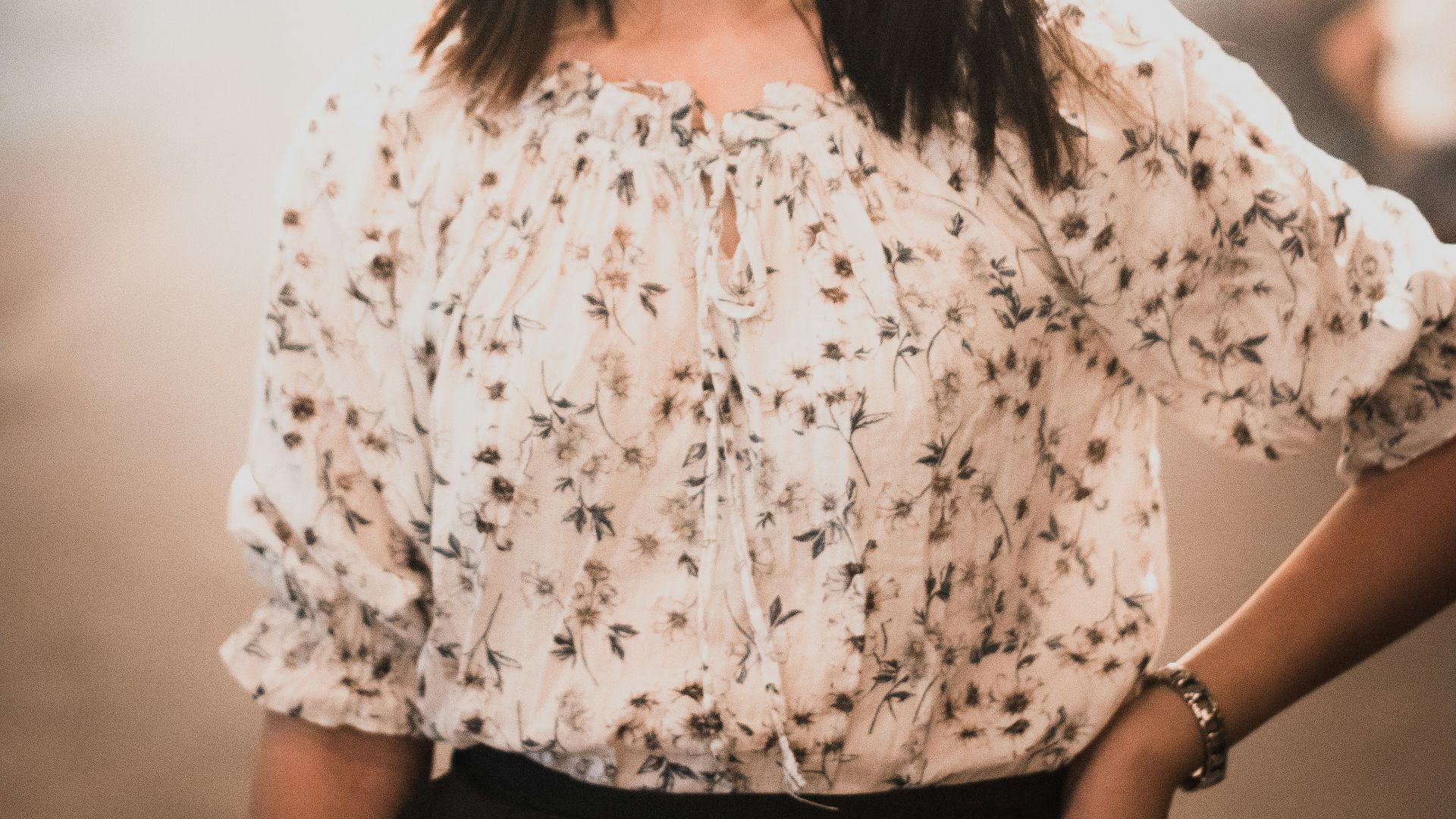 woman wears white floral blouse