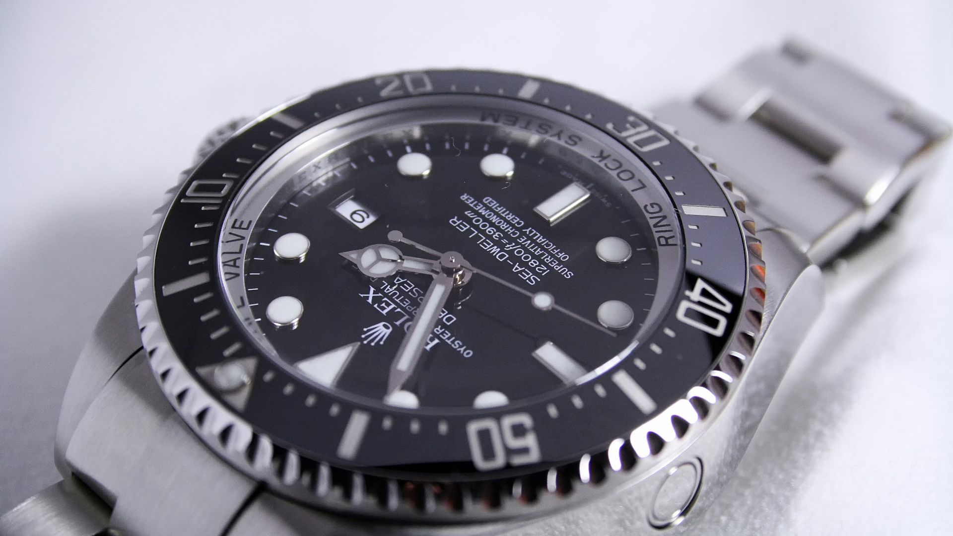 silver-colored Rolex analog watch reading at 1:55