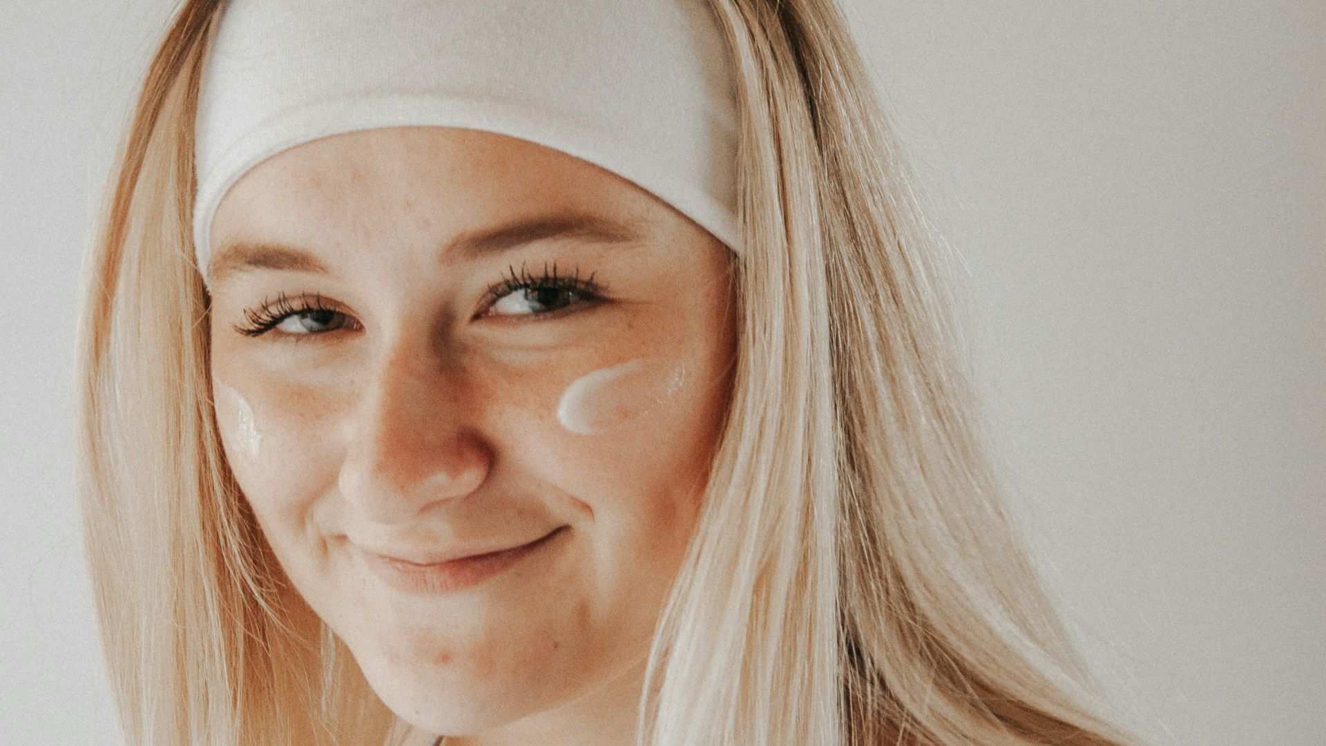 woman in white tank top smiling