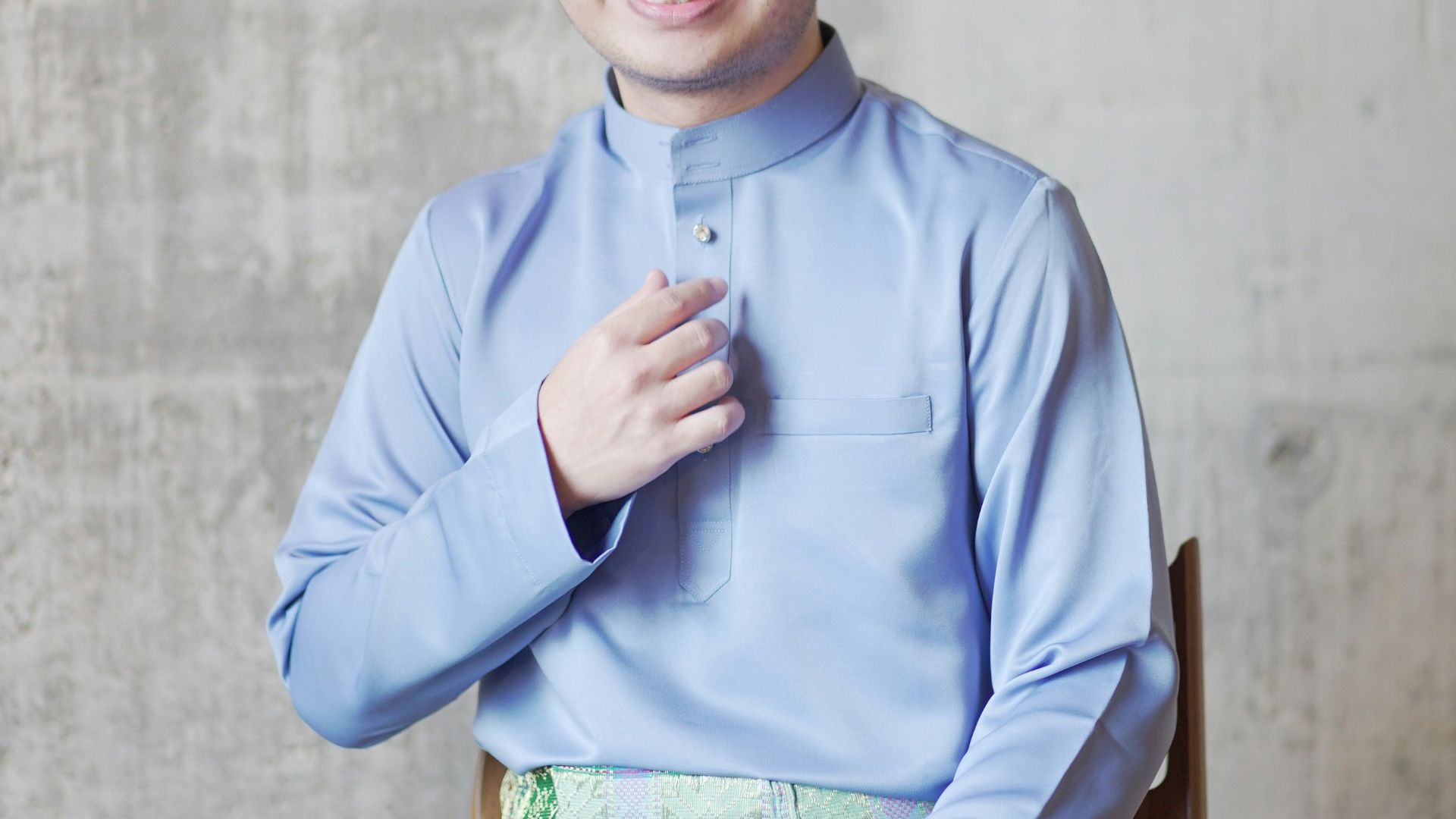 man in blue dress shirt and green and white plaid skirt