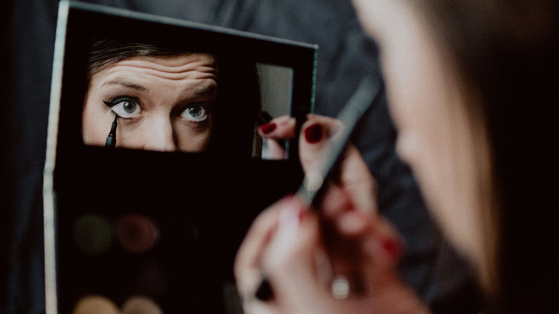 woman holding black framed mirror