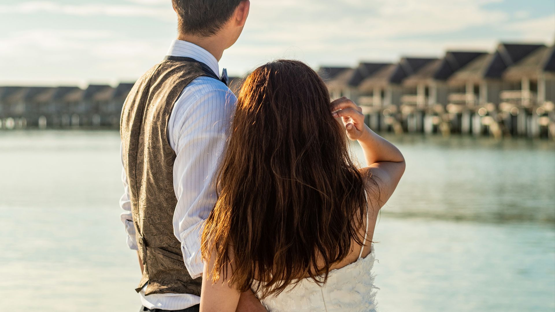 man and woman kissing near body of water during daytime