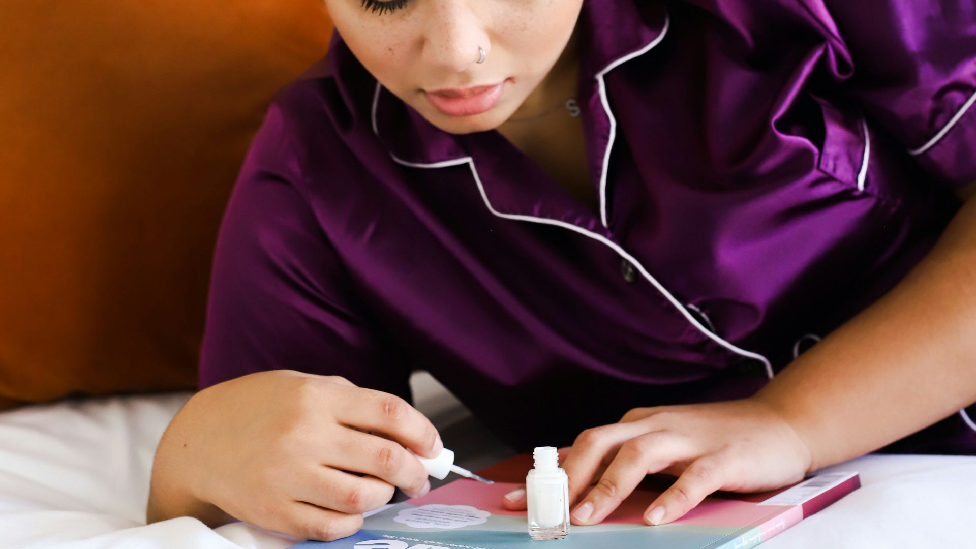 man in purple shirt using white earbuds