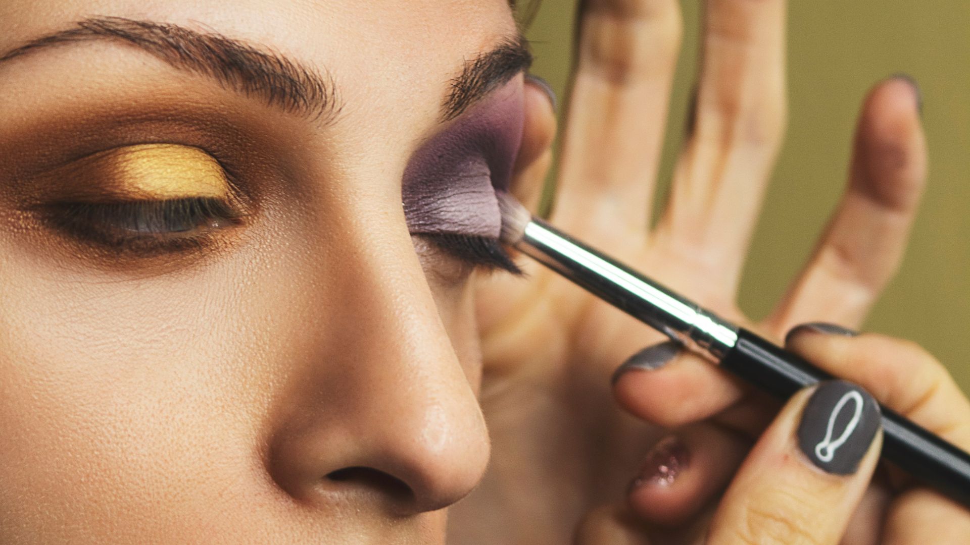 woman with pink lipstick holding black pen