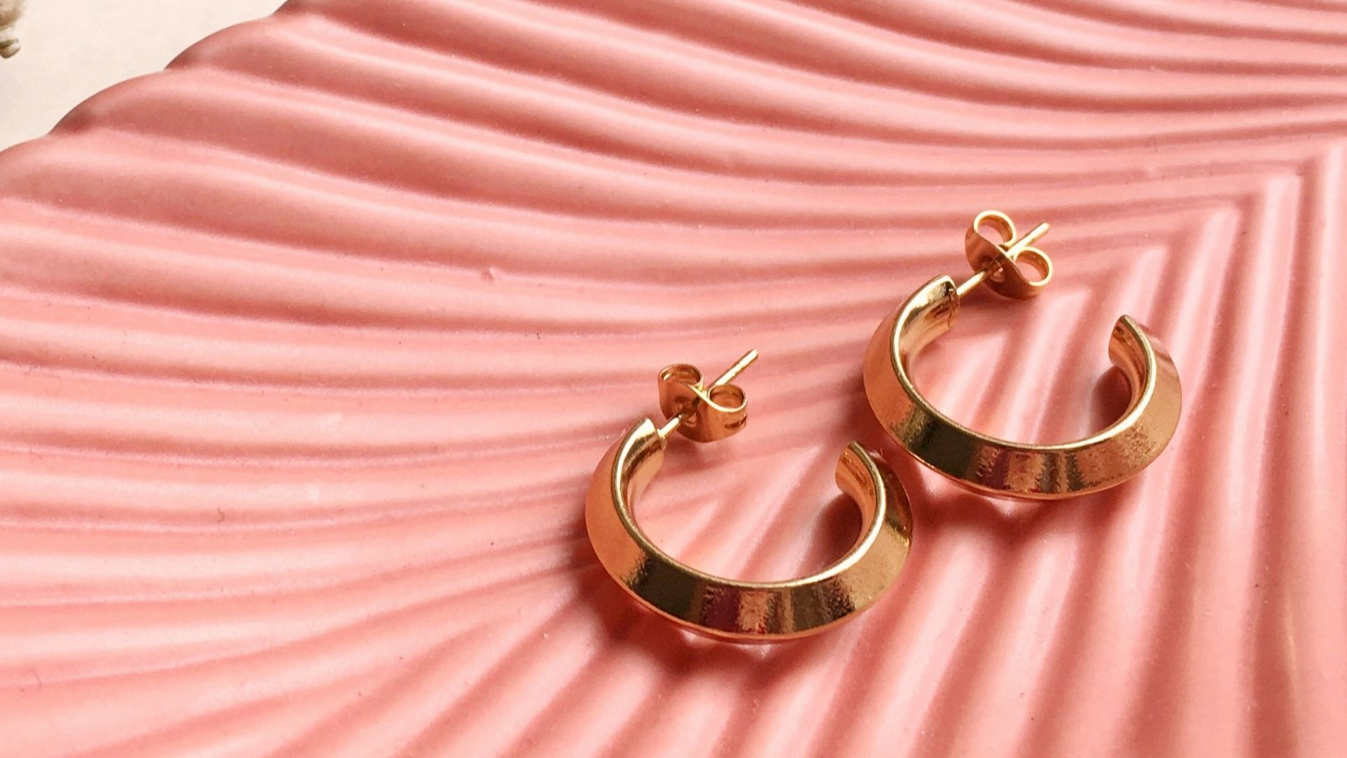 gold and silver rings on pink and white striped textile