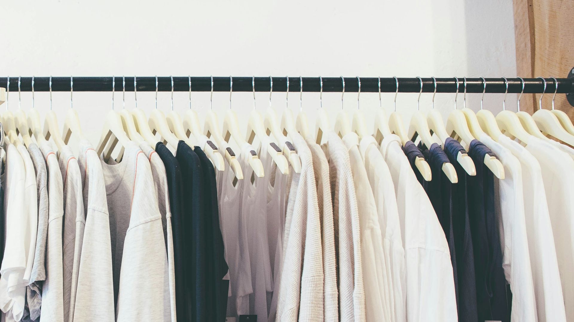 white long sleeve shirt hanging on black steel rack