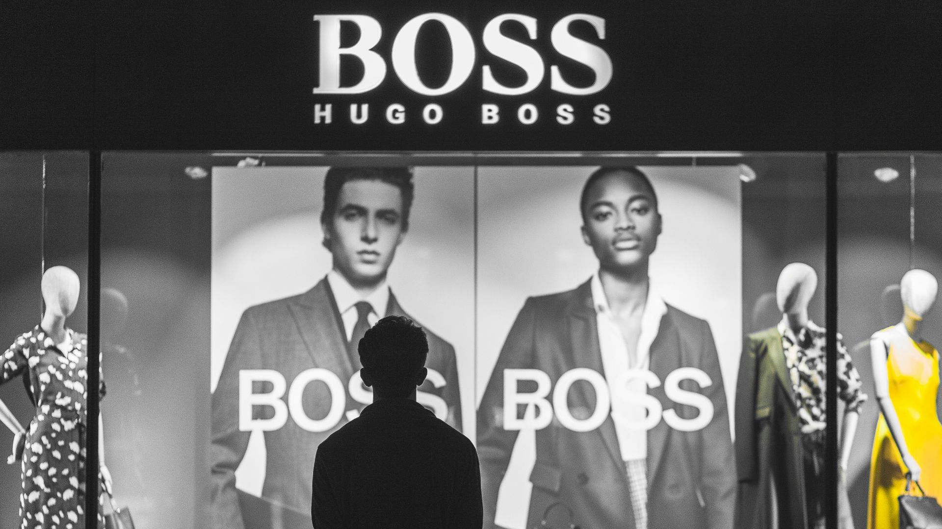 man standing in front of Boss Hugo Boss store