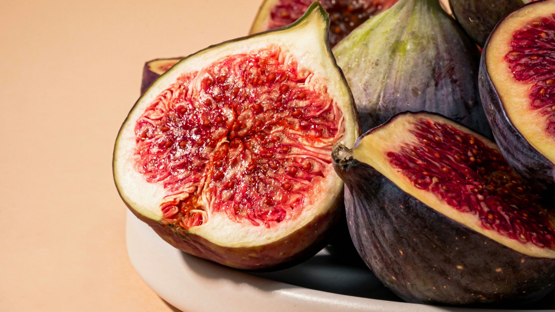 a white plate topped with sliced figs on top of a table