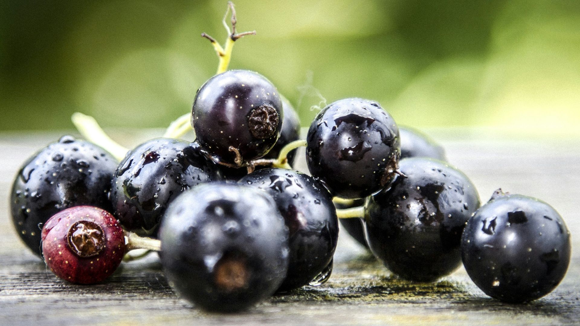 a bunch of black berries sitting on top of a wooden table