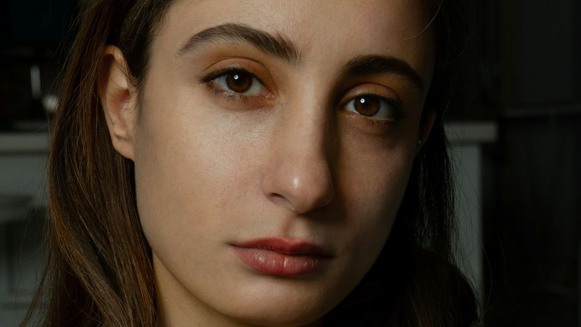 a woman with brown eyes and a gray shirt