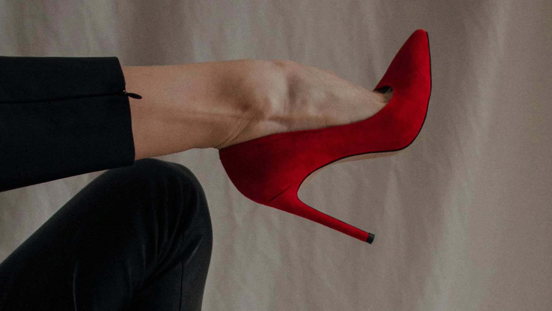 person in black pants and red shoes