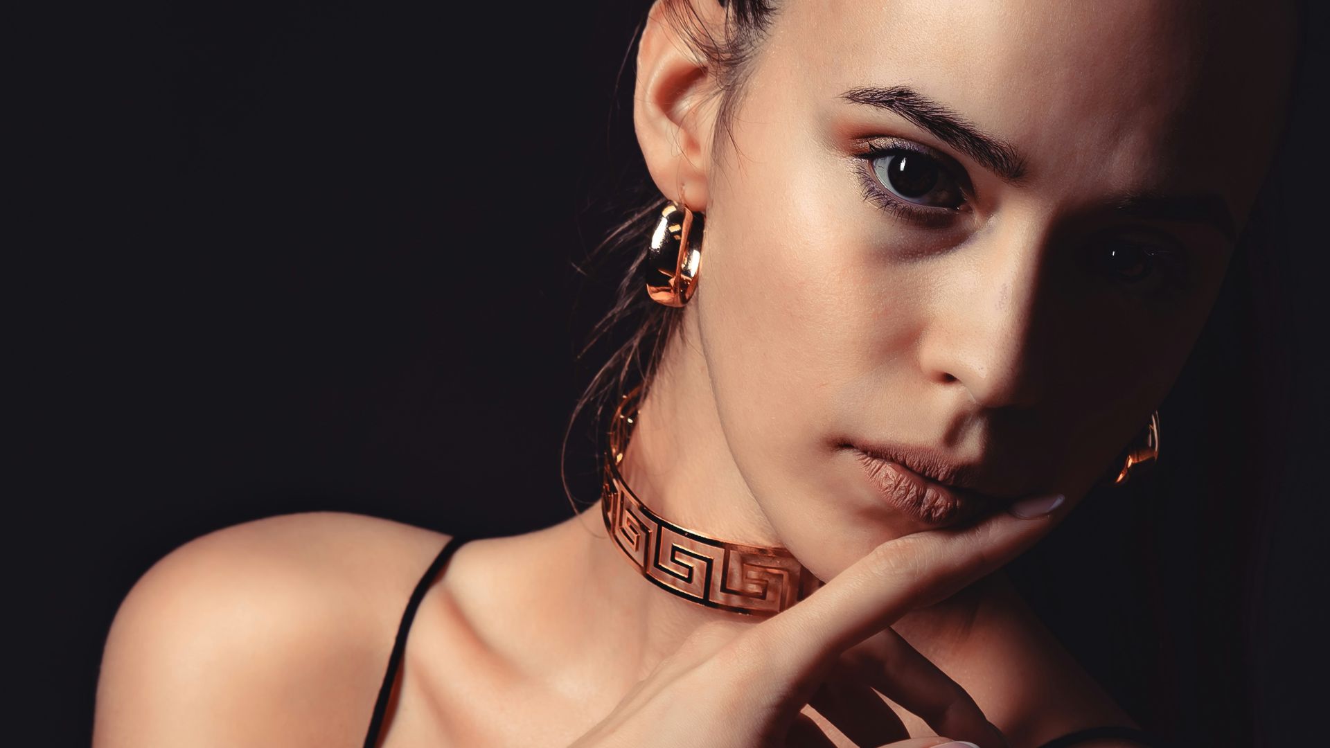 Woman wearing ornate gold greek key jewelry set