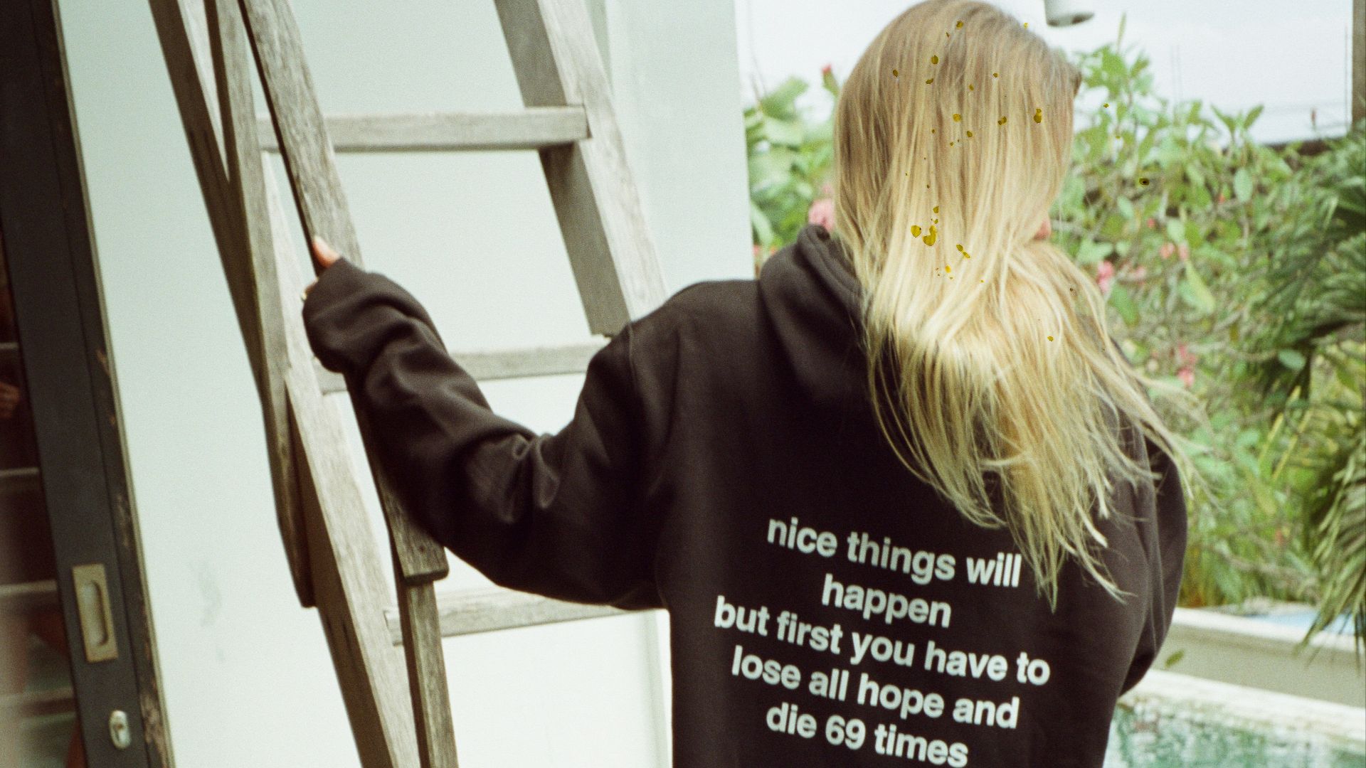 a woman standing on a ladder next to a pool