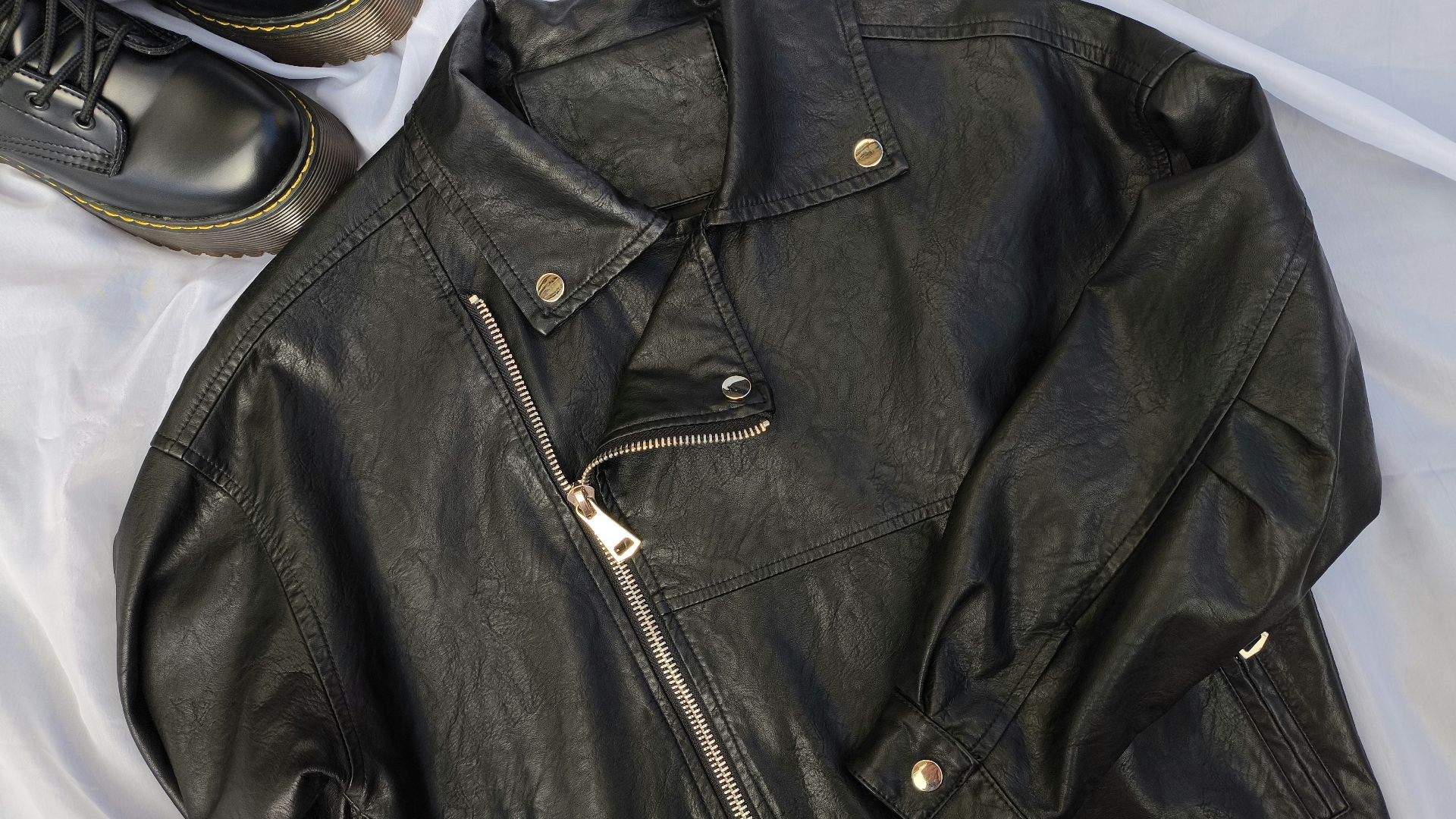 A pair of black shoes and a black leather jacket