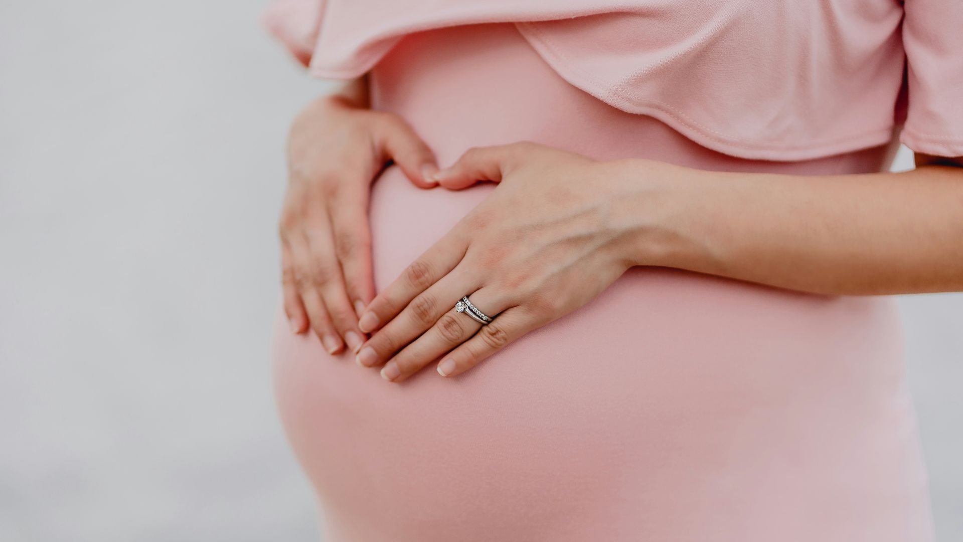 woman wearing gold ring and pink dress
