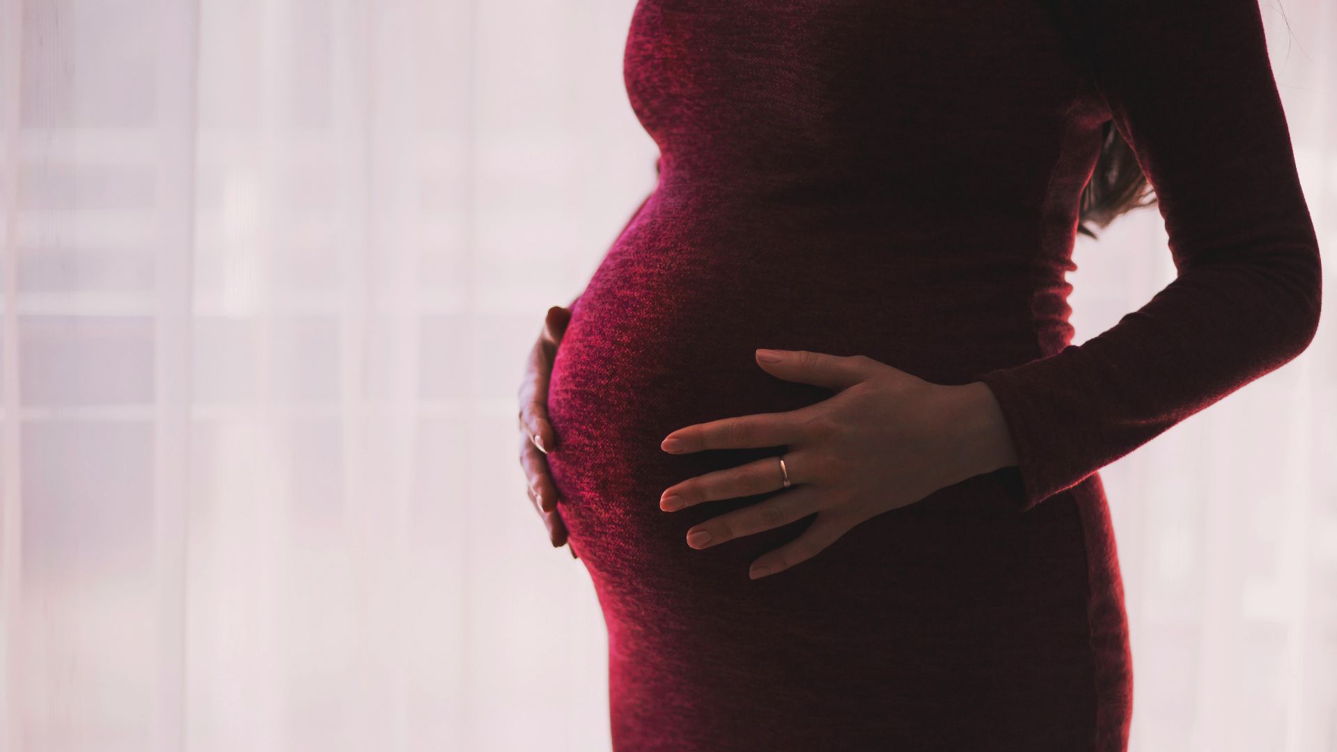 pregnant woman wearing red long-sleeved dress