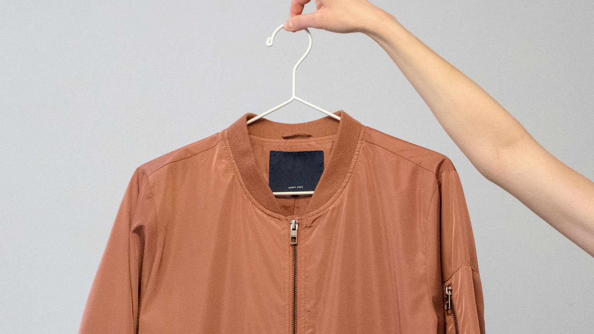 brown long sleeve shirt on white clothes hanger