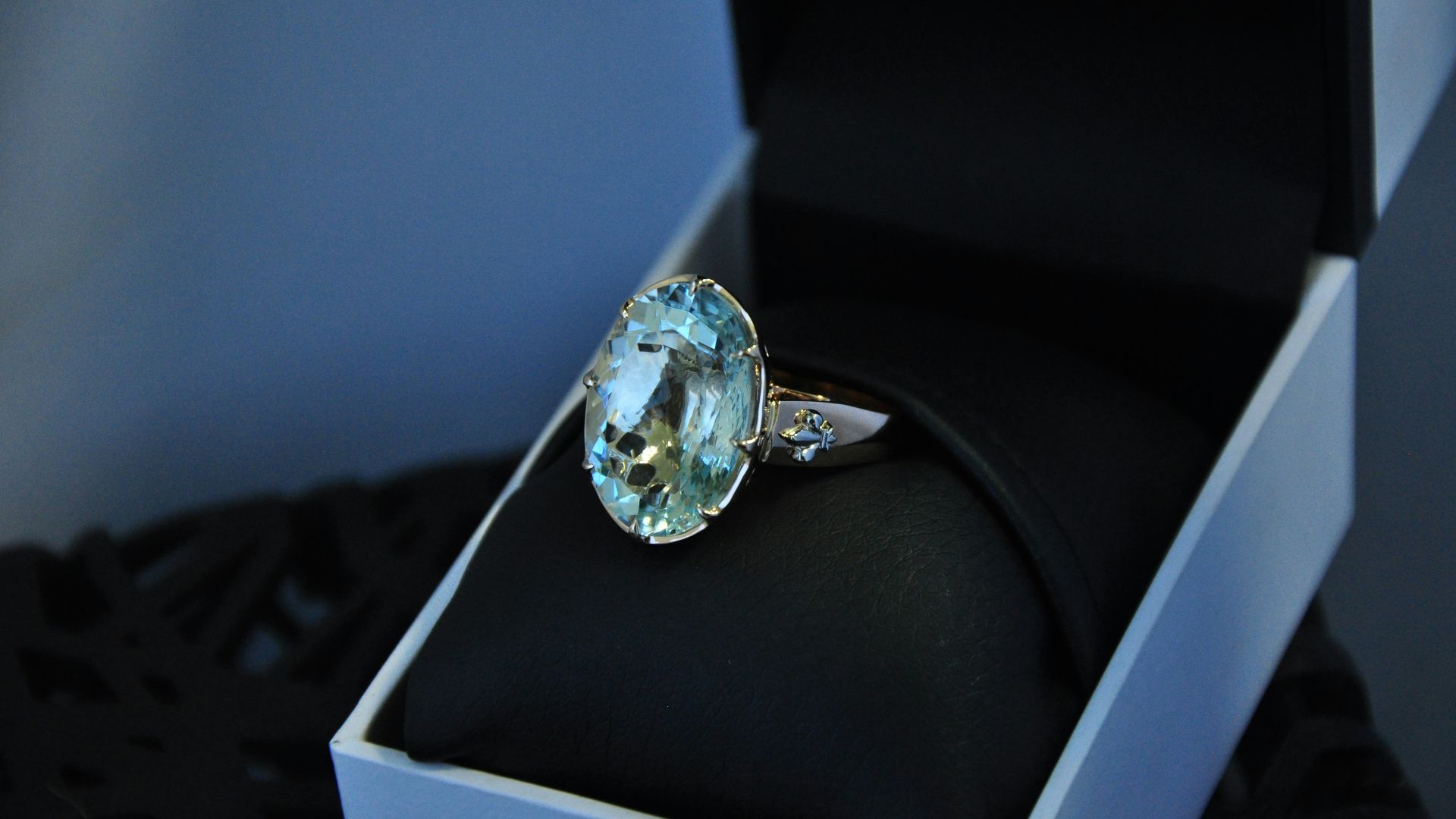 a ring with a blue topaz sits in a box