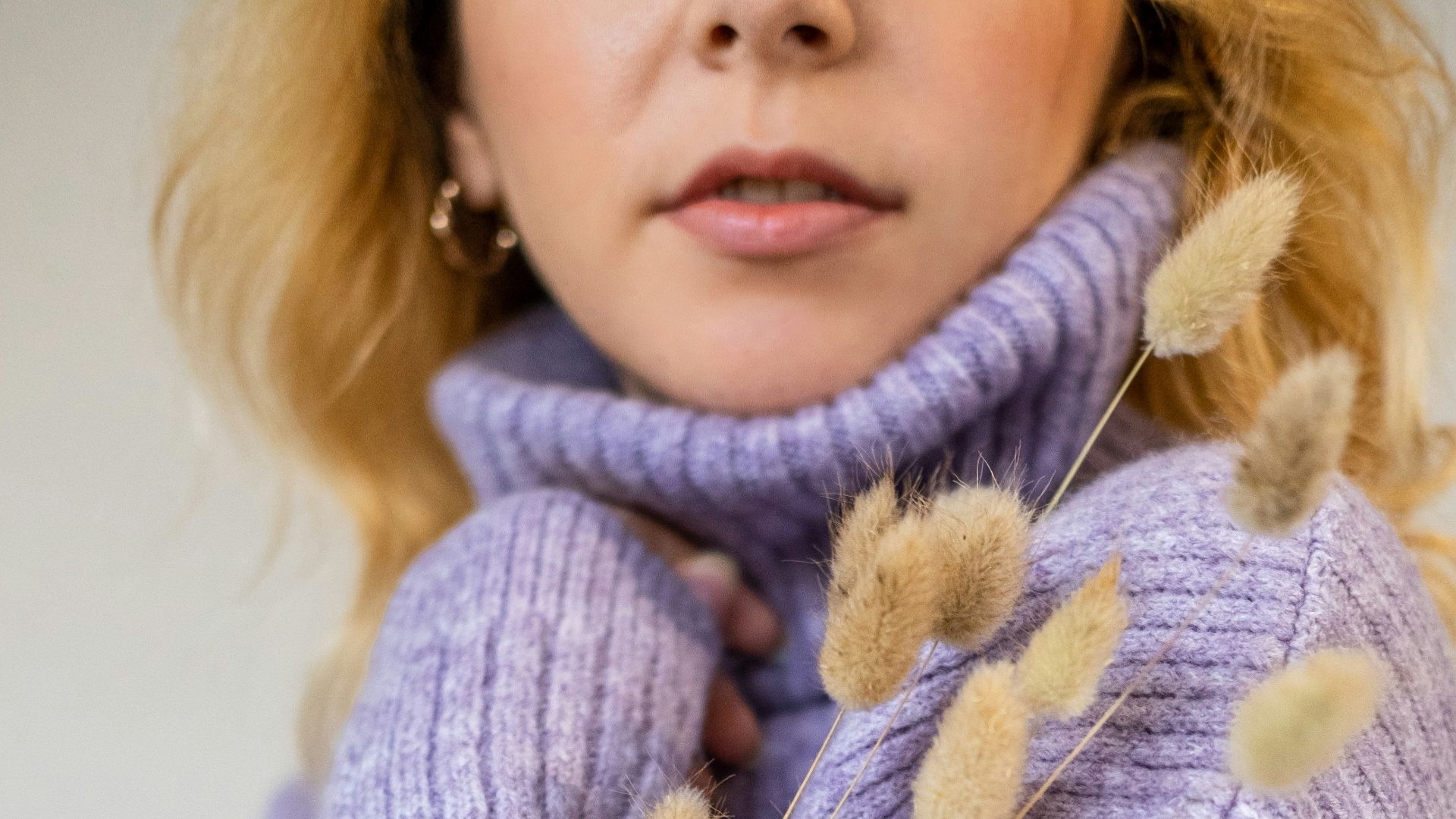 a woman wearing a purple sweater and a ring