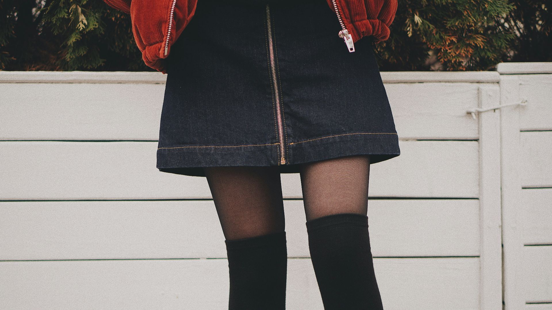 woman wearing black denim skirt and thigh high socks