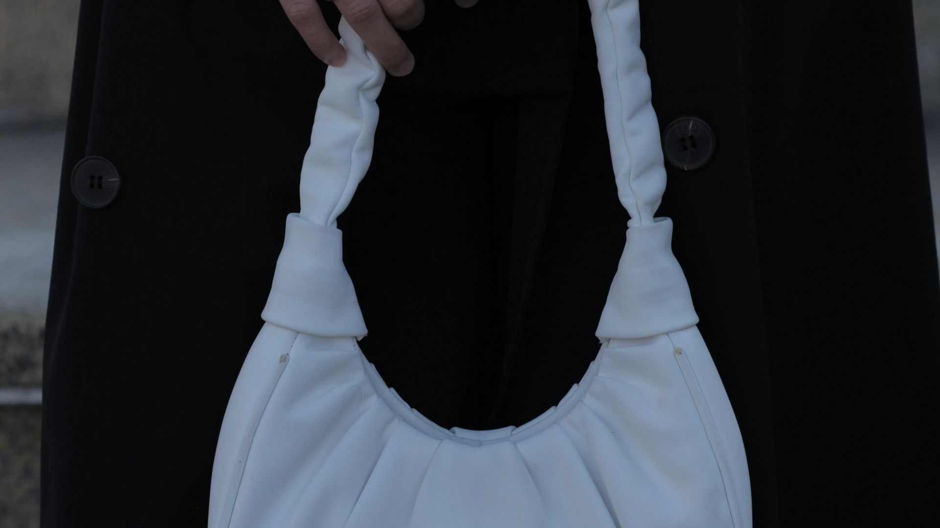 a person holding a white purse