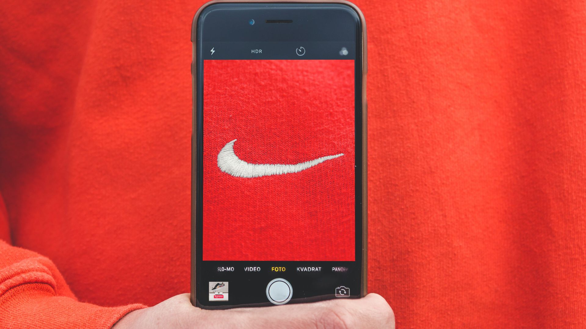 person holding iPhone taking picture on Nike label