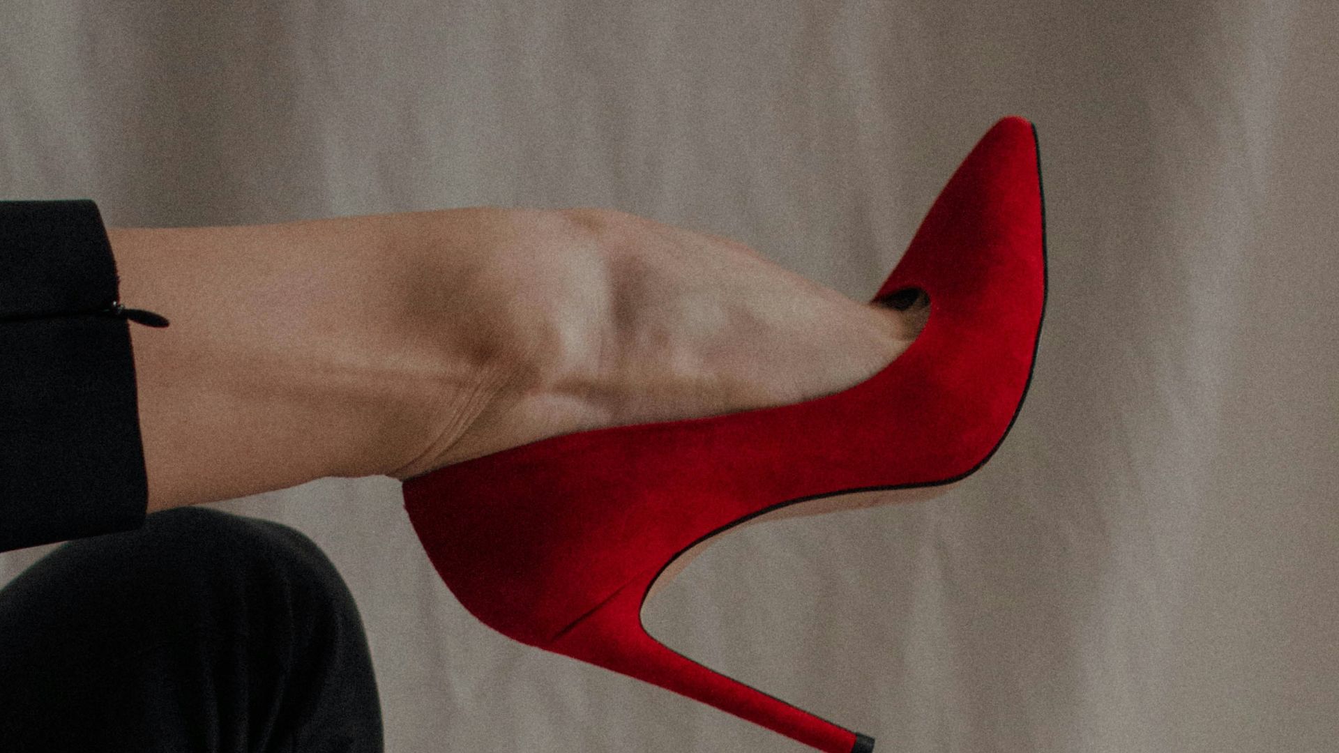 person in black pants and red shoes