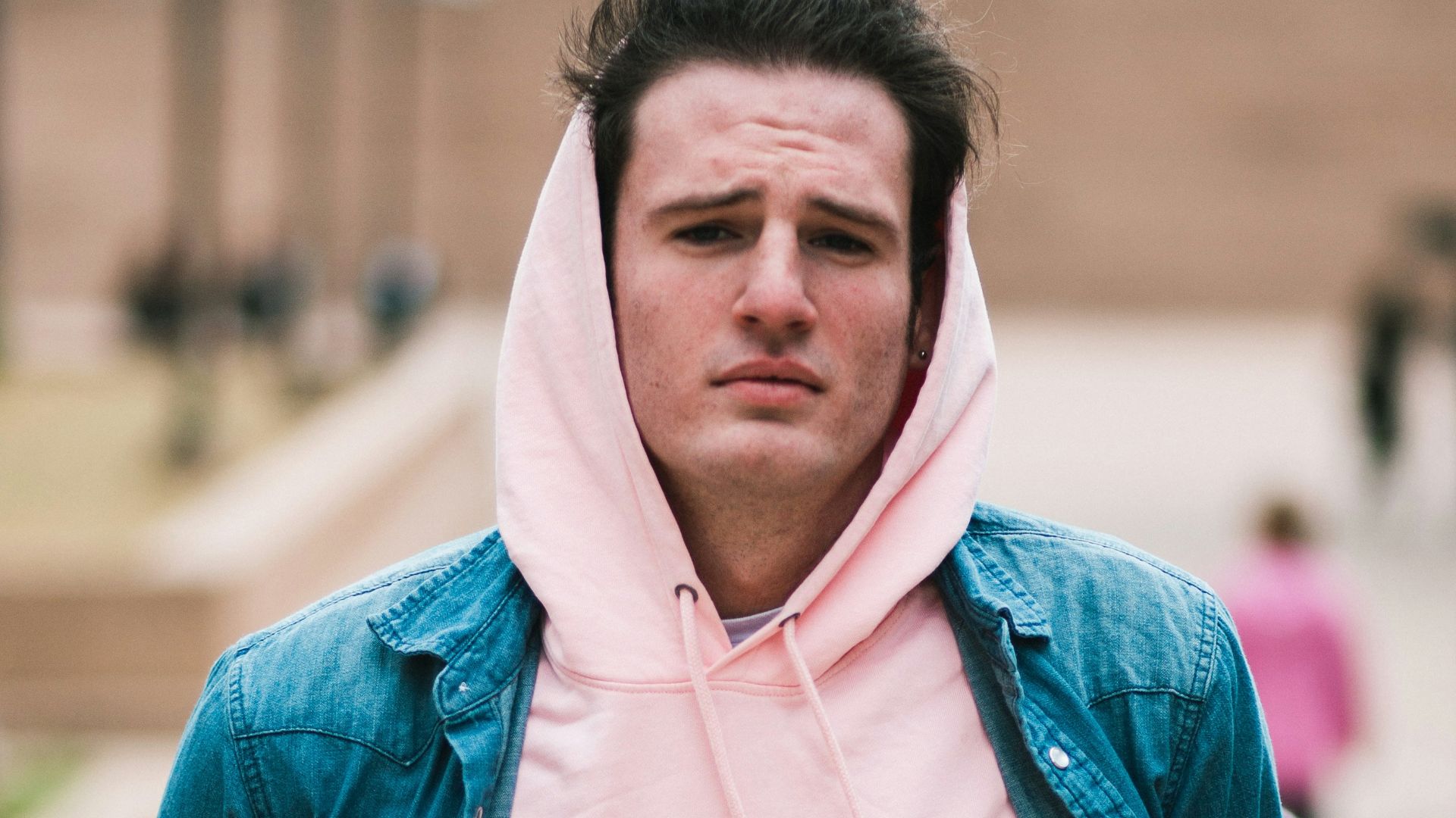 man in pink pullover hoodie and blue button-up shirt